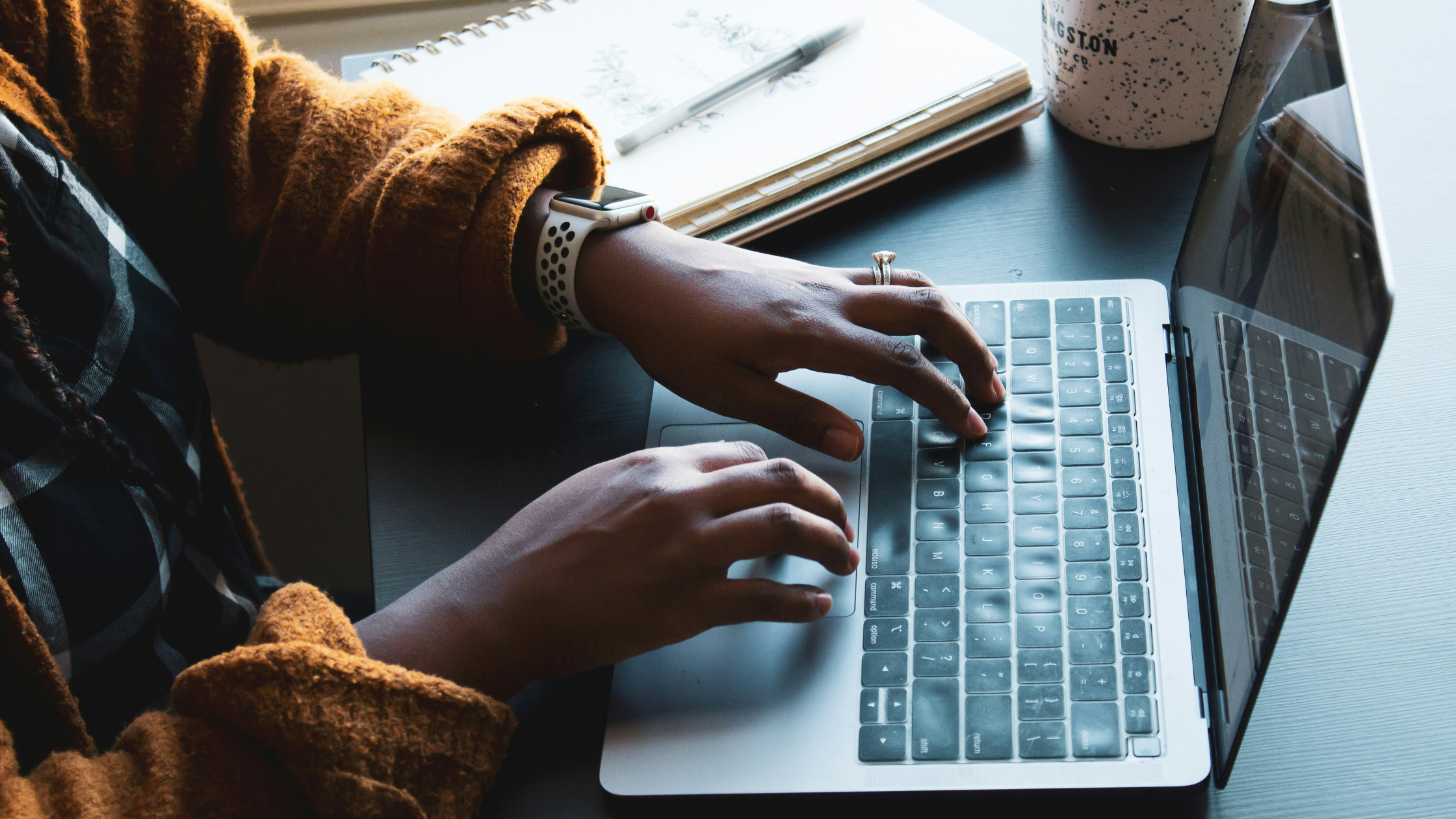 Woman typing on a computer in a coffee shop